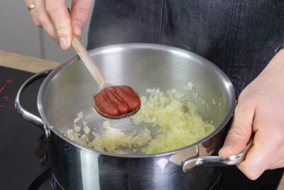 Gemüsewürfeln anschwitzen und Tomatenmark dazugeben