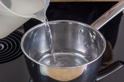 Wasser in den Topf geben