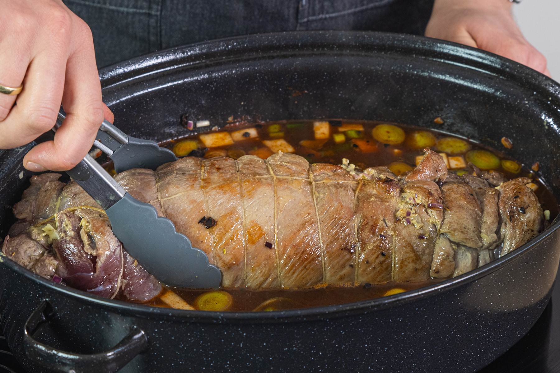 Wildschwein-Rollbraten in den Sud geben