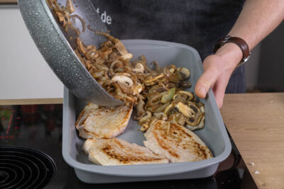 Zwiebeln über dem Schnitzel verteilen