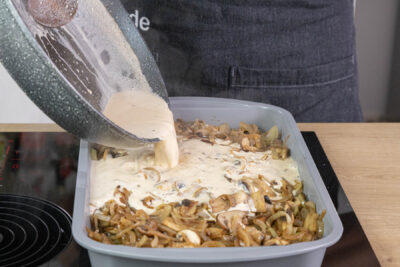 Soße über das Zwiebelschnitzel gießen