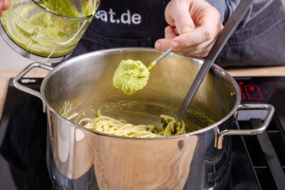 Avocado-Creme zu den Spaghetti geben