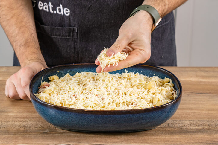 Käse über Nudel-Schinken-Gratin streuen