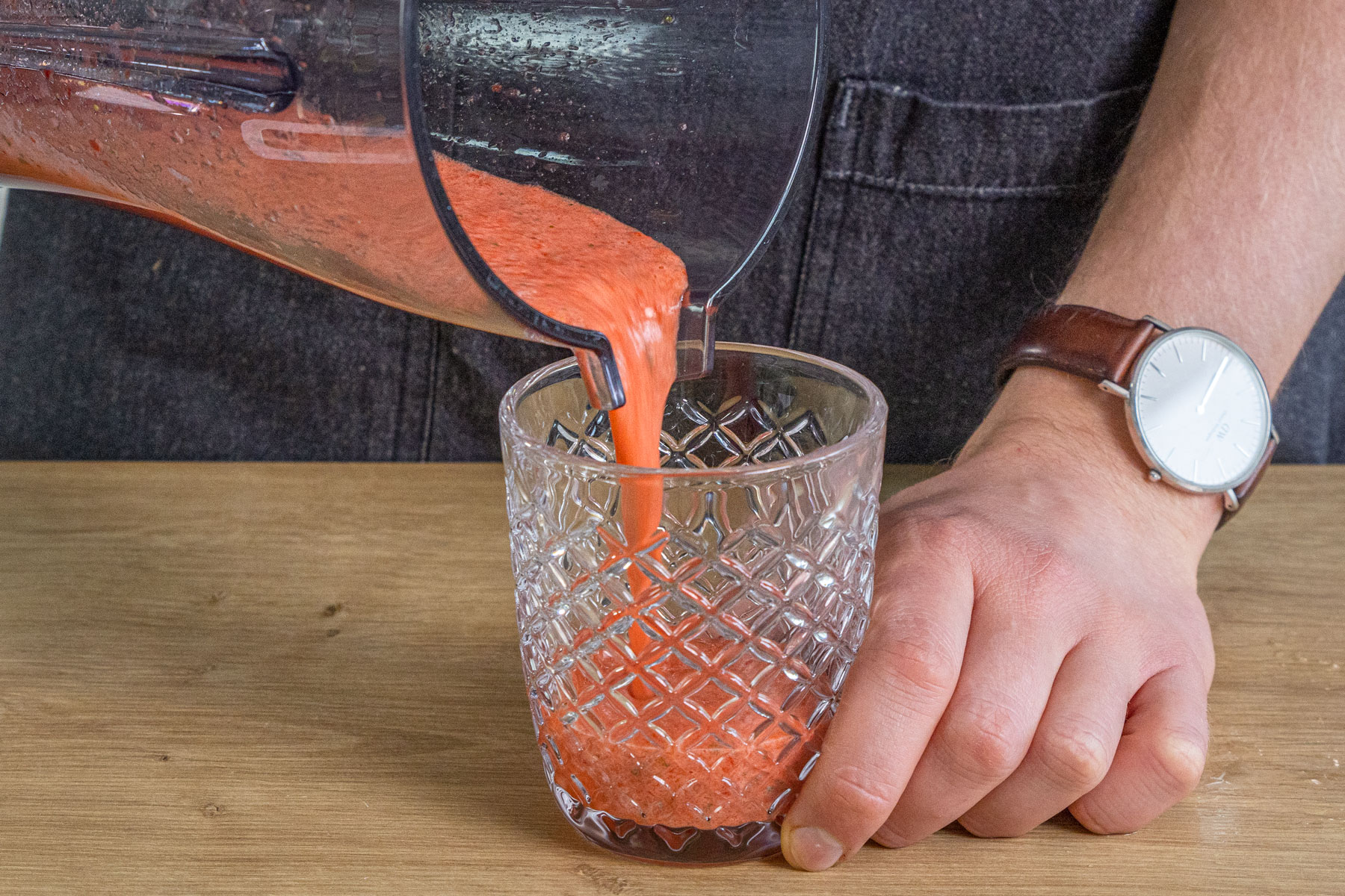 Erdbeer-Mojito Cocktail in ein Glas gießen