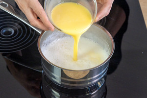 angerührtes Puddingpulver zur Milch in den Topf gießen