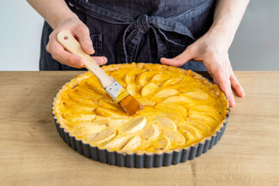 französischer Apfeltarte mit Marmelade bestreichen