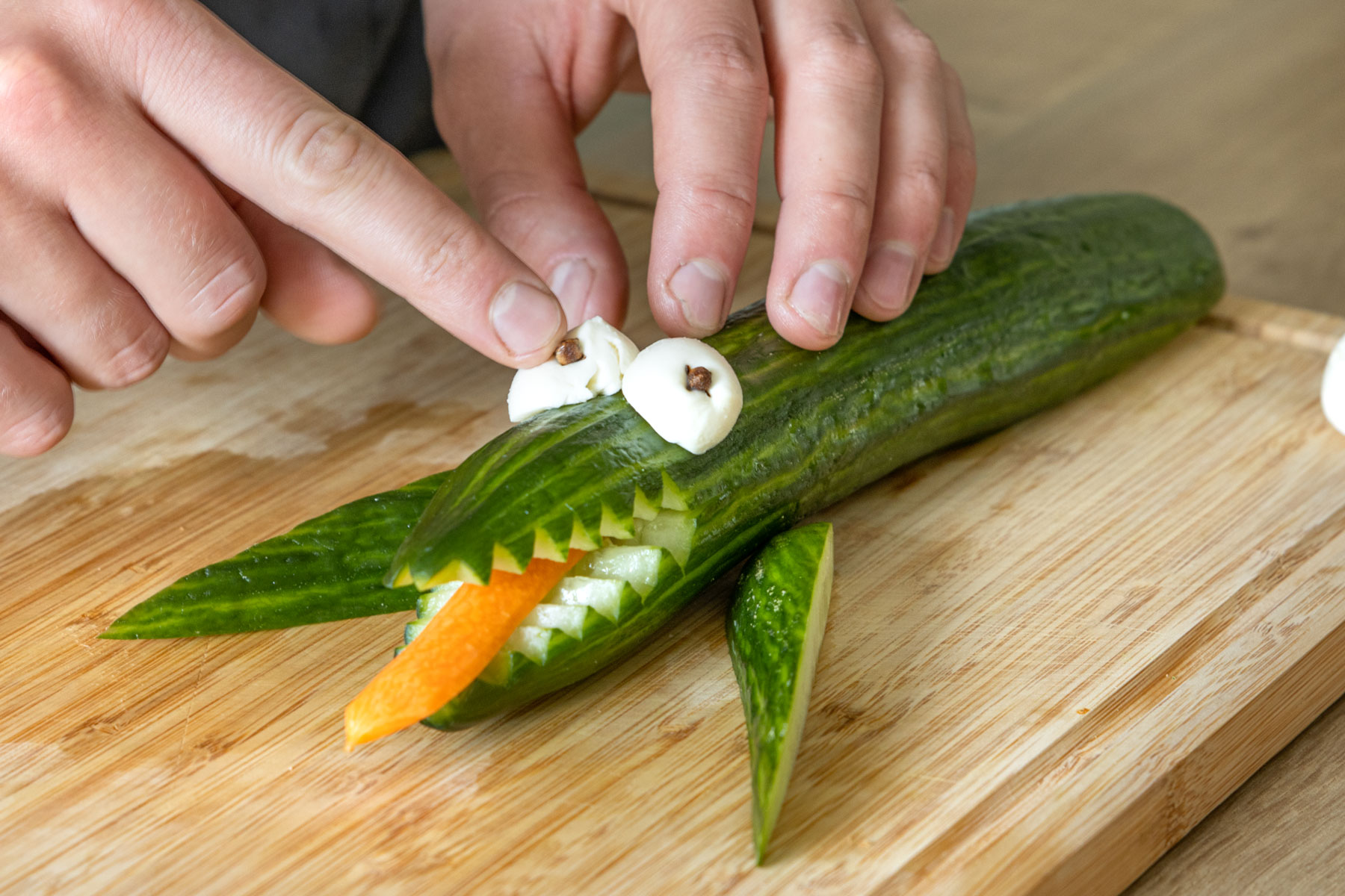 Augen des Gurkenkrokodils mit Mozzarella machen