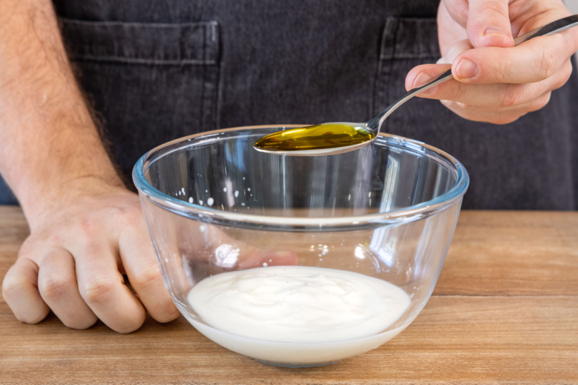 Olivenöl zum Joghurt-Salatdressing geben