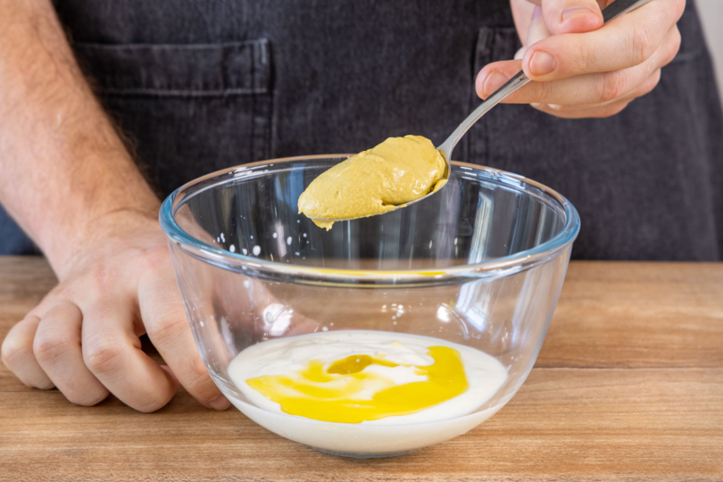 Joghurt-Salatdressing mit Senf vermischen