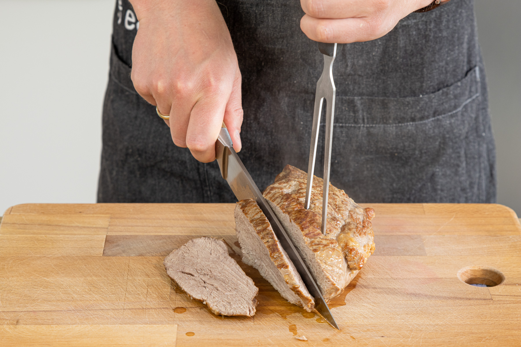 Kalbsbraten aus dem Römertopf aufschneiden