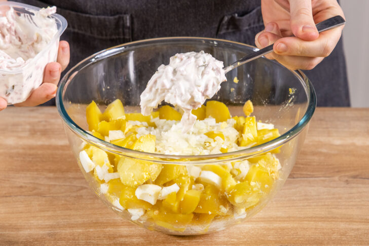 Fleischsalat zum Kartoffelsalat geben
