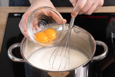 Milch mit Eier und Zucker erhitzen