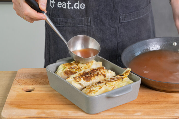 Soße über die Kohlrouladen geben
