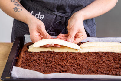 Bananenhälften auf Schokoboden verteilen