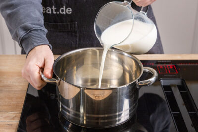 Milch in den Topf gießen