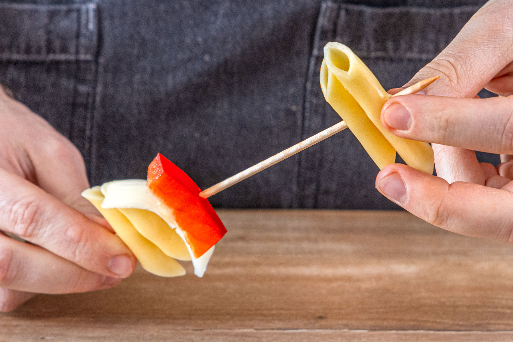Nudeln, Käse und Paprika aufspießen