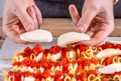 Nudelspieße mit Mozzarella toppen