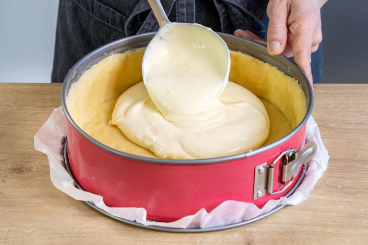 Quarkcreme auf den Mürbeteigboden geben