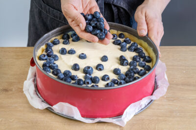 Blaubeeren auf dem Kuchen verteilen