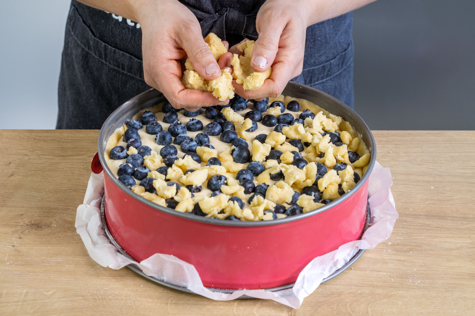 Streusel über Omas Blaubeerkuchen geben