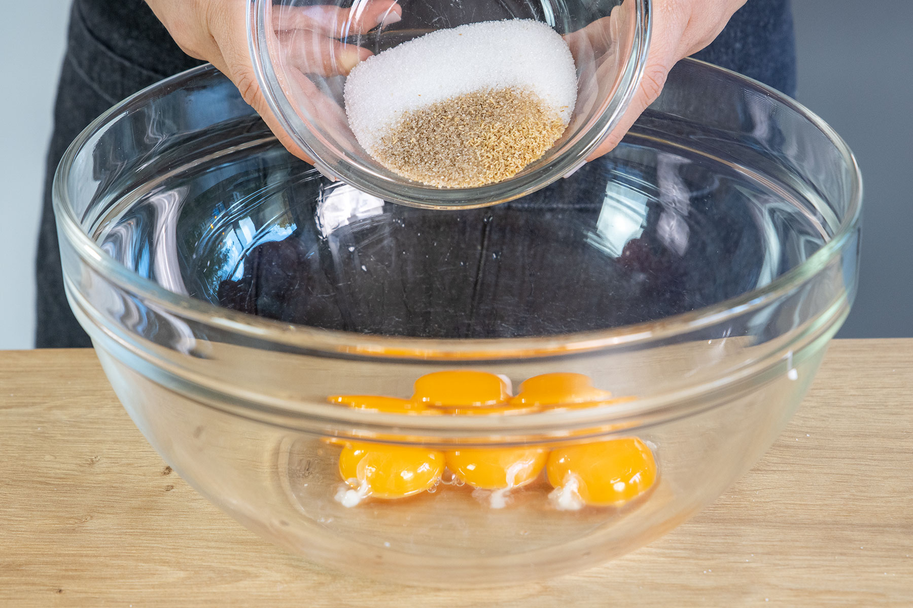 Zucker, Vanillezucker und Tonkabohnenabrieb und Wasser zum Eigelb geben