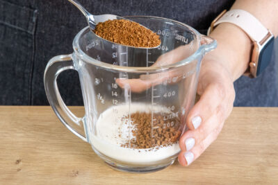 Instant-Kaffeepulver zur Sahne geben