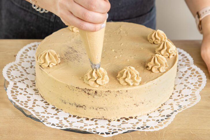 Creme als Tupfen auf die Mokkatorte spritzen