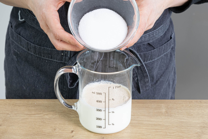 Trockenhefe und Zucker in lauwarmer Milch verrühren