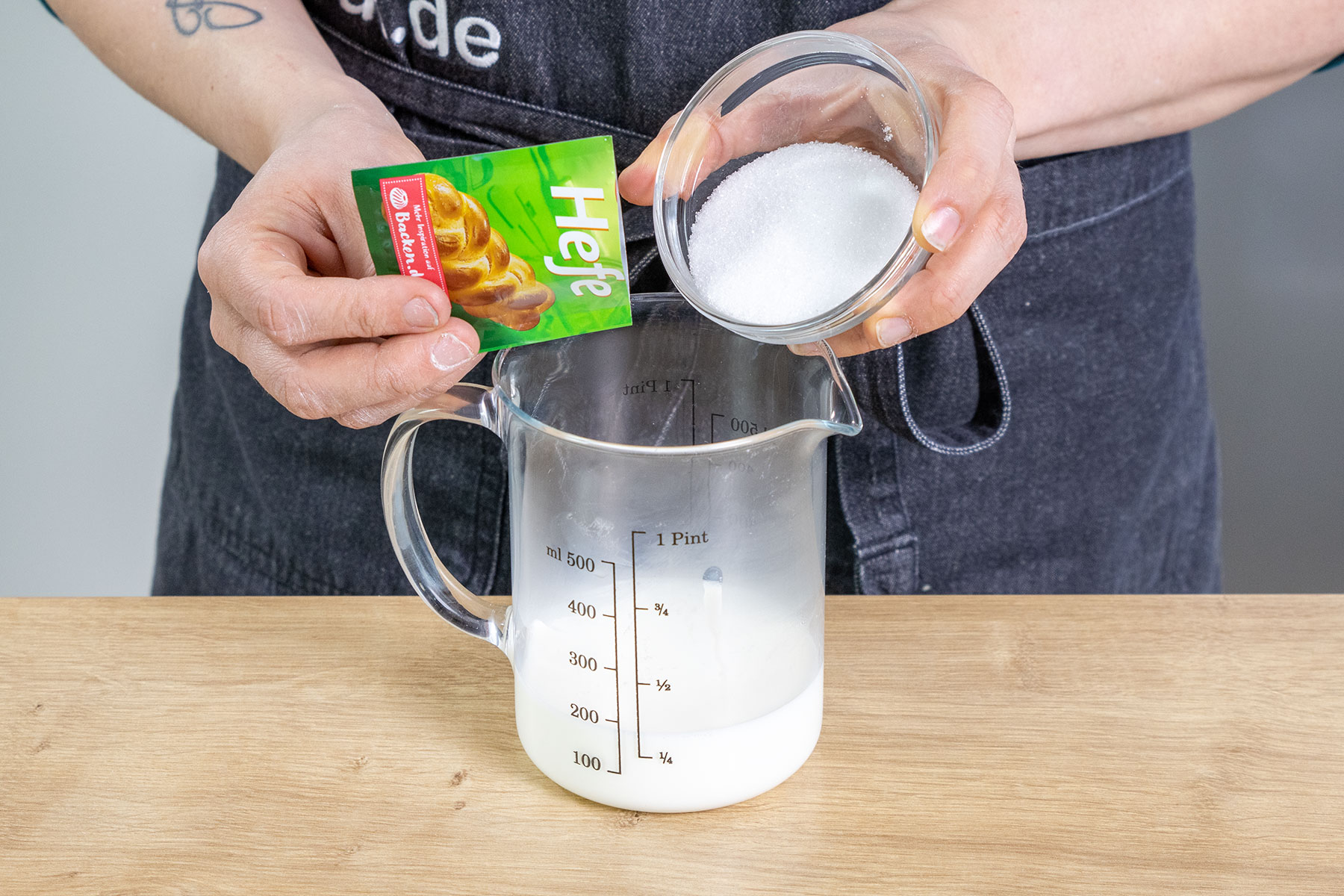 Zucker und Hefe zur warmen Milch geben