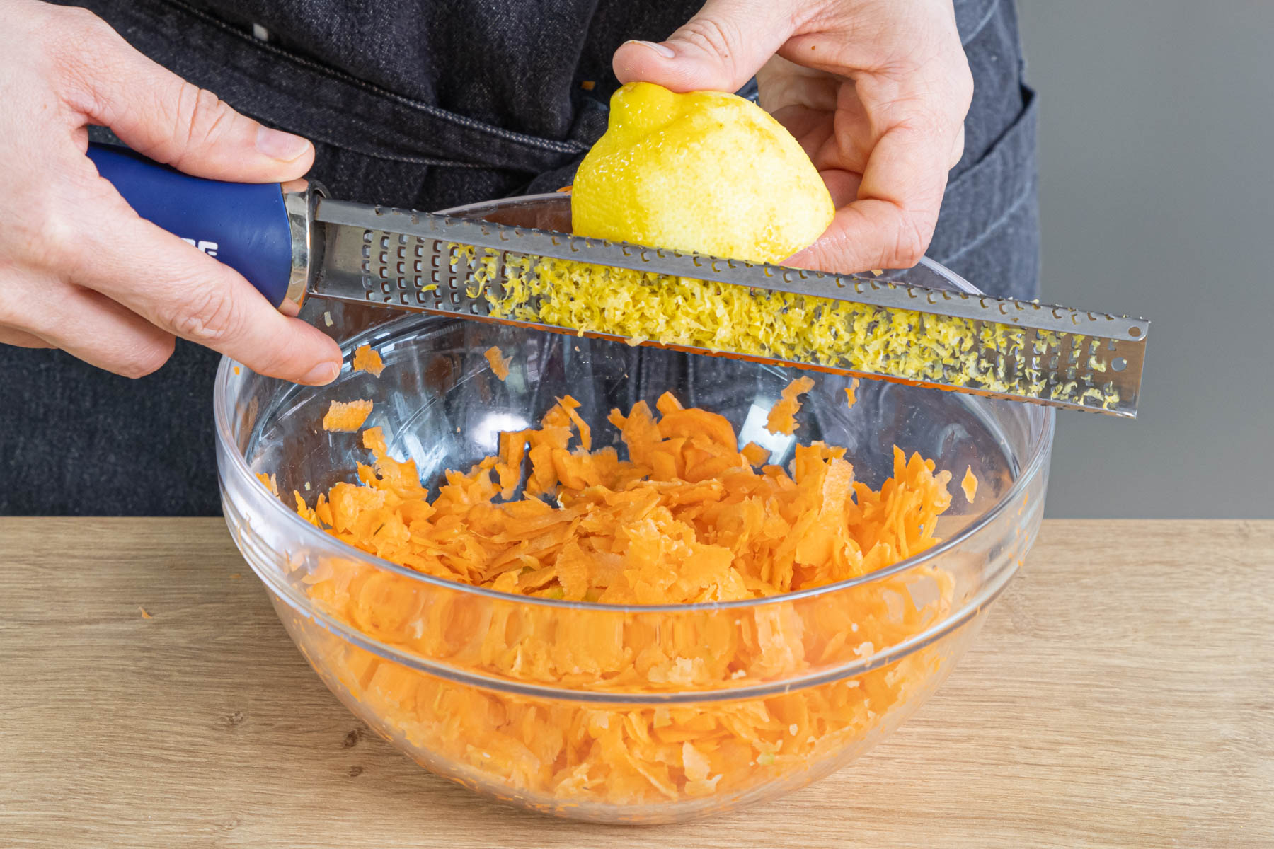 Zitronenschale zu den Karotten raspeln