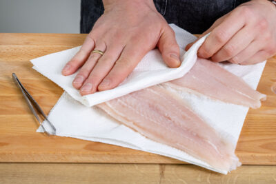 Pangasiusfilets mit Küchenpapier abtupfen