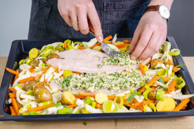 Pangasiusfilets auf dem Gemüse mit der Kruste bedecken