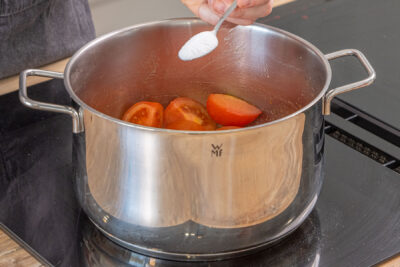 Zucker zu den Tomaten geben