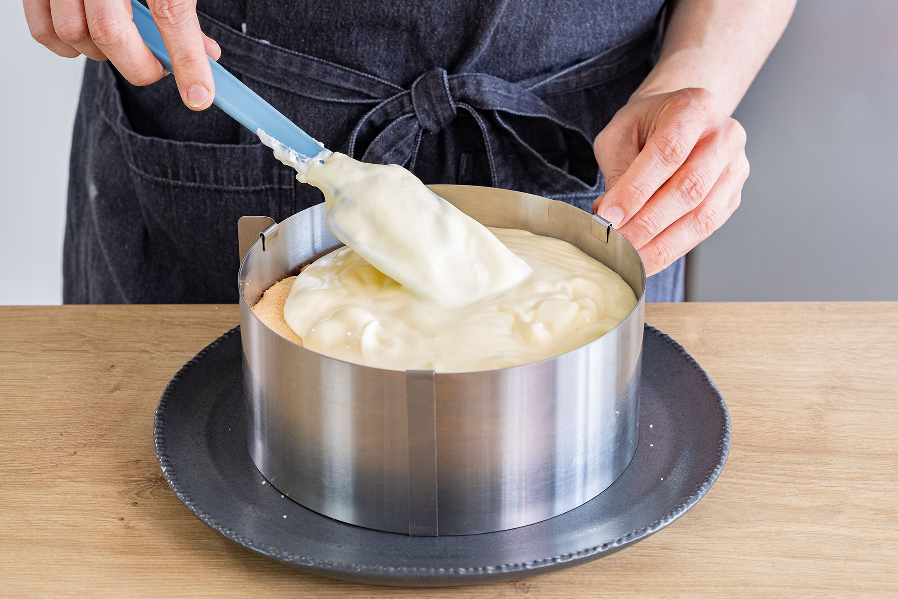Joghurtmasse auf Pfirsich-Maracuja-Torte verteilen