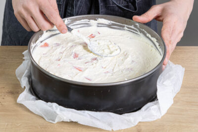 Frischkäse-Creme auf dem Tortenboden verstreichen