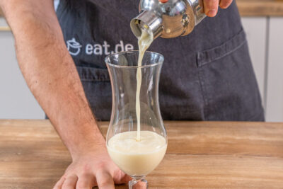 Pina Colada Cocktail in das Glas gießen