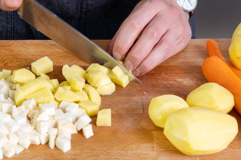 Sellerie, Karotten und Kartoffeln in kleine Stücke schneiden