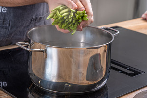 Wasser zum Kochen bringen und Gemüse hineingeben