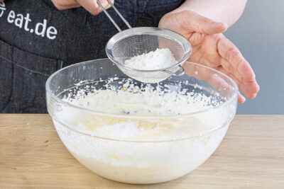 Puddingpulver in die Quarkmasse sieben
