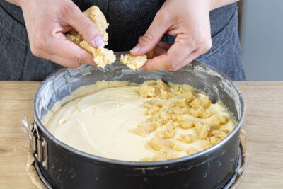 Streusel auf dem Quarkkuchen verteilen