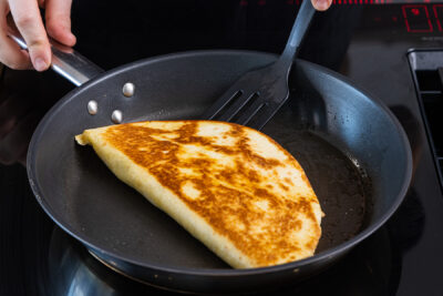 Quesadillas mit Hähnchen in der Pfanne wenden