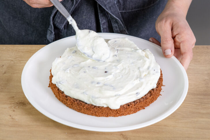 Creme auf den ersten Boden des Schokokusskuchens geben