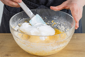 Eischnee zur Eigelbmasse hinzugeben