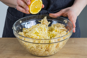 Den Saft einer Zitrone zu den Äpfeln geben