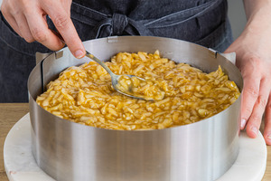 Die Pudding-Apfel-Masse auf den Tortenboden verstreichen