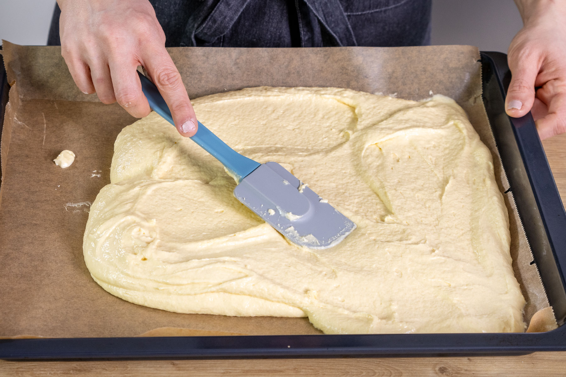 Teig des Selterwasserkuchen auf dem Backblech verstreichen