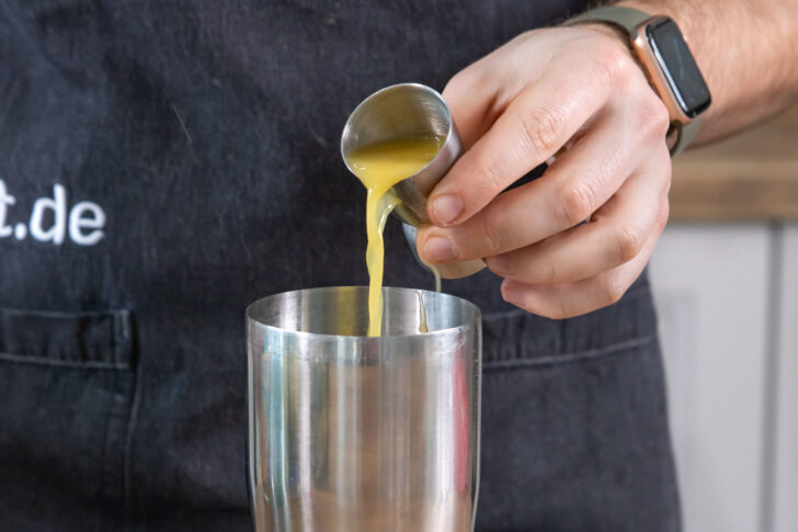 Orangensaft in Cocktailshaker gießen