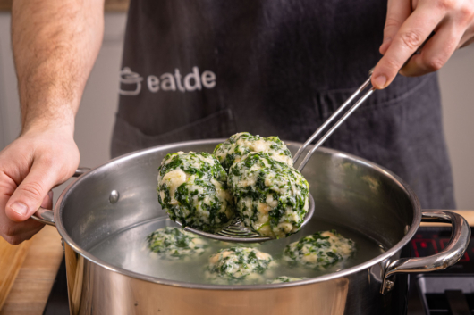 Knödel aus dem Wasser nehmen