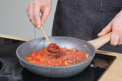 Frische Tomaten und Tomatenmark dazugeben