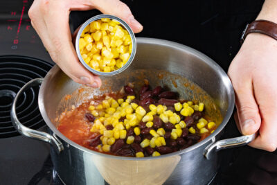 Mais und Kidneybohnen zur Tomatensauce geben